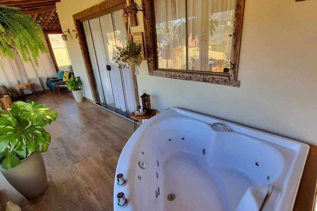 Un espace bien-être comprenant un grand jacuzzi, un sol en bois et des plantes en pot.