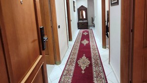 A hallway with wooden doors, a red carpet, and a mirror. - Modern apartment Guéliz center - spacious - Parking (Marrakech)