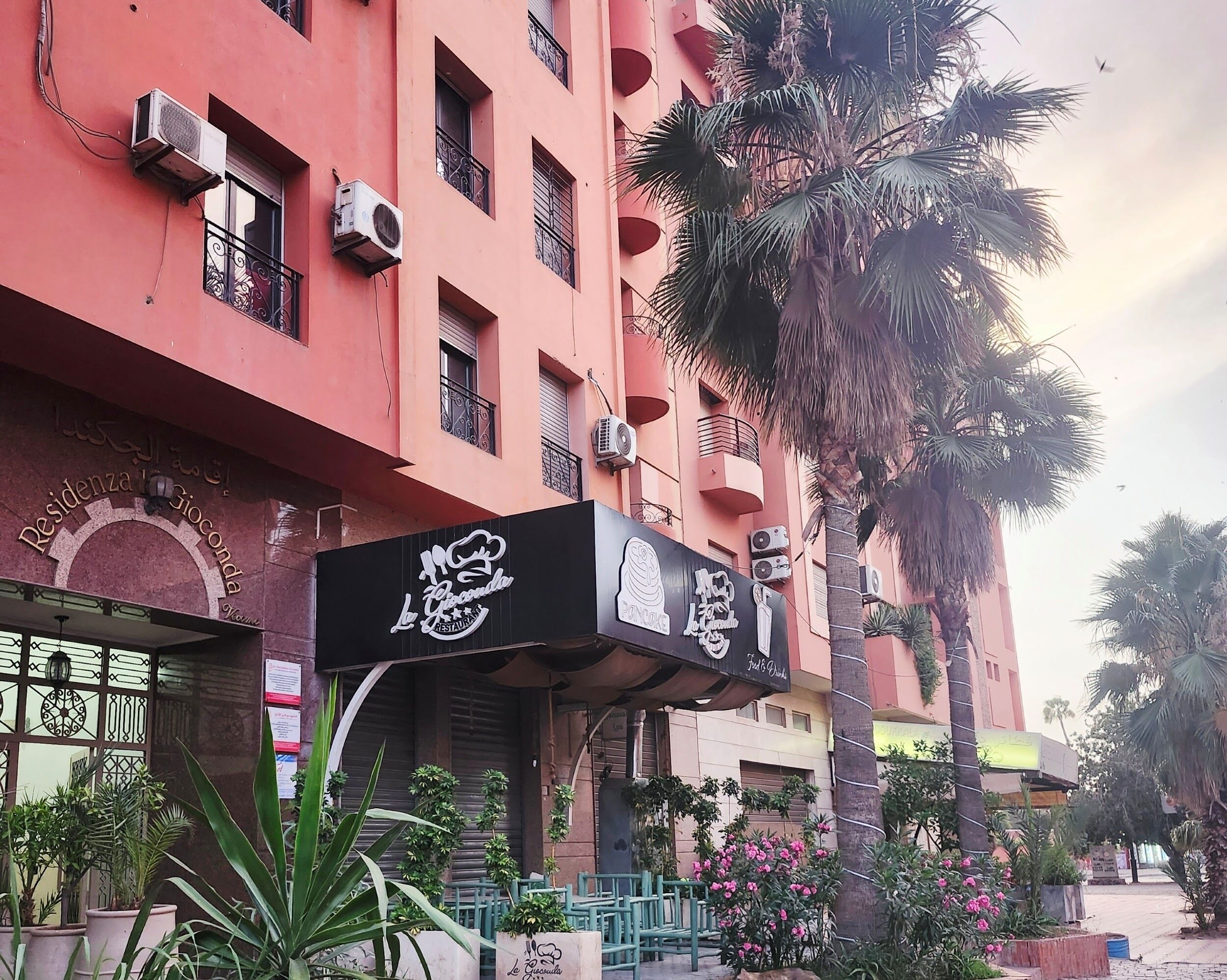 A building with a sign for 'La Piccola Ristorante' and a sign for 'Residence Gioconda.'