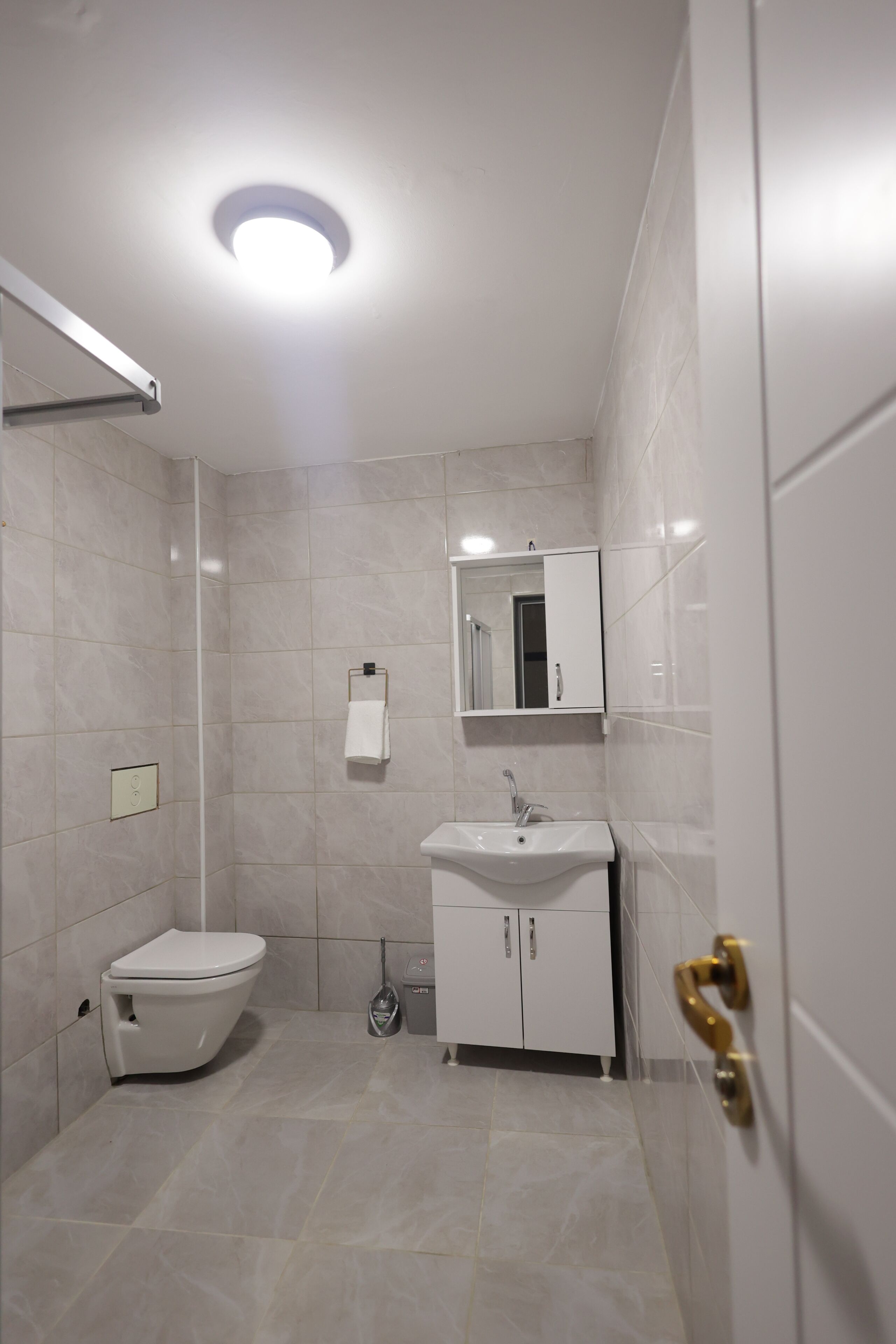 A modern bathroom with a toilet, sink, and mirror.