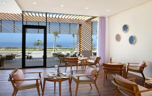 Un espace extérieur moderne, aménagé avec du mobilier en bois et offrant une vue sur la mer.