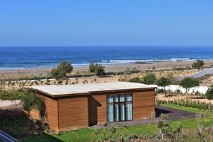 En la playa, sillas reclinables de playa, sombrillas, toallas de playa