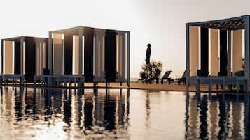 A poolside area with lounge chairs and a statue.
