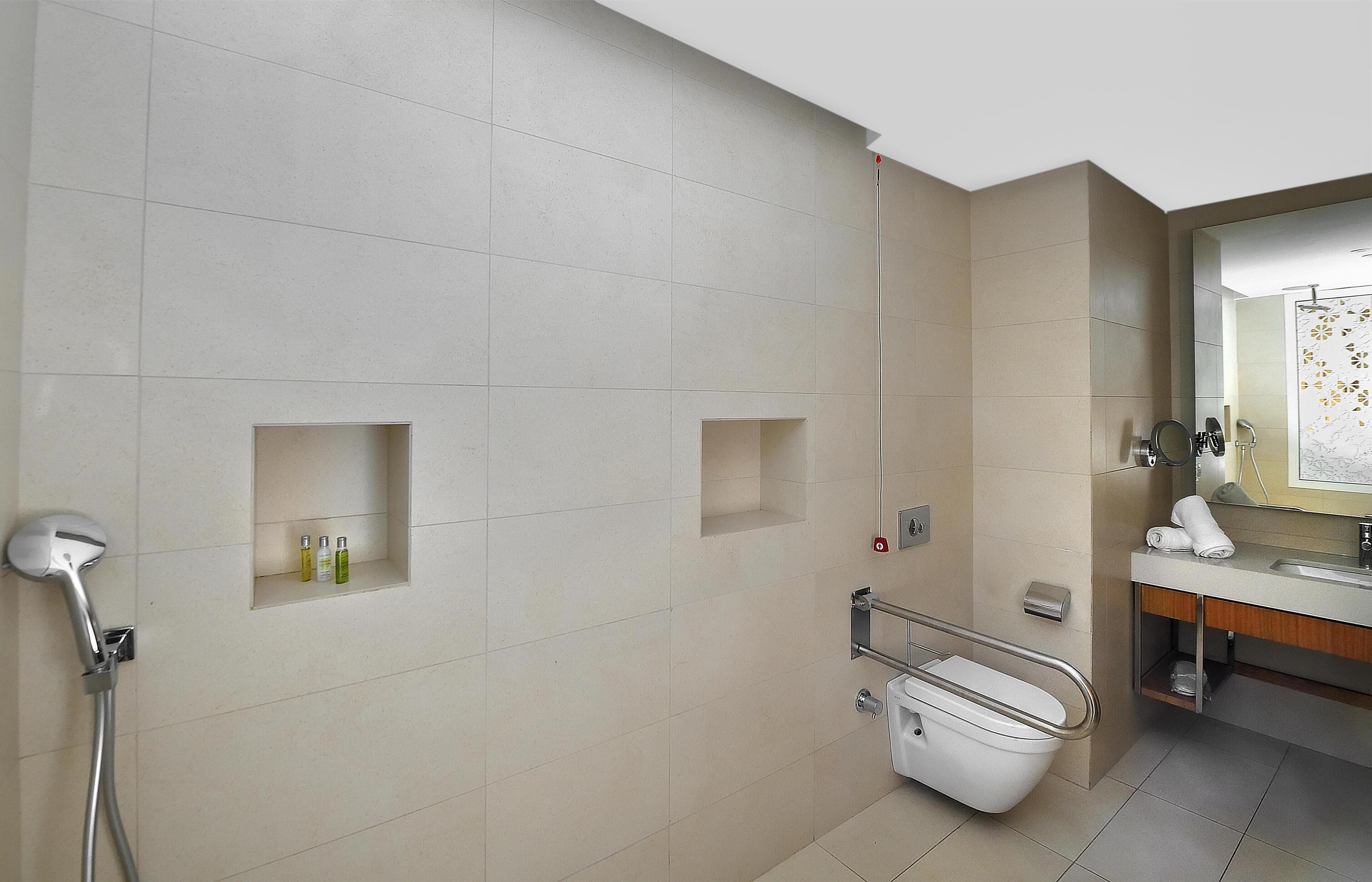 A modern bathroom with a shower, toilet, and sink.