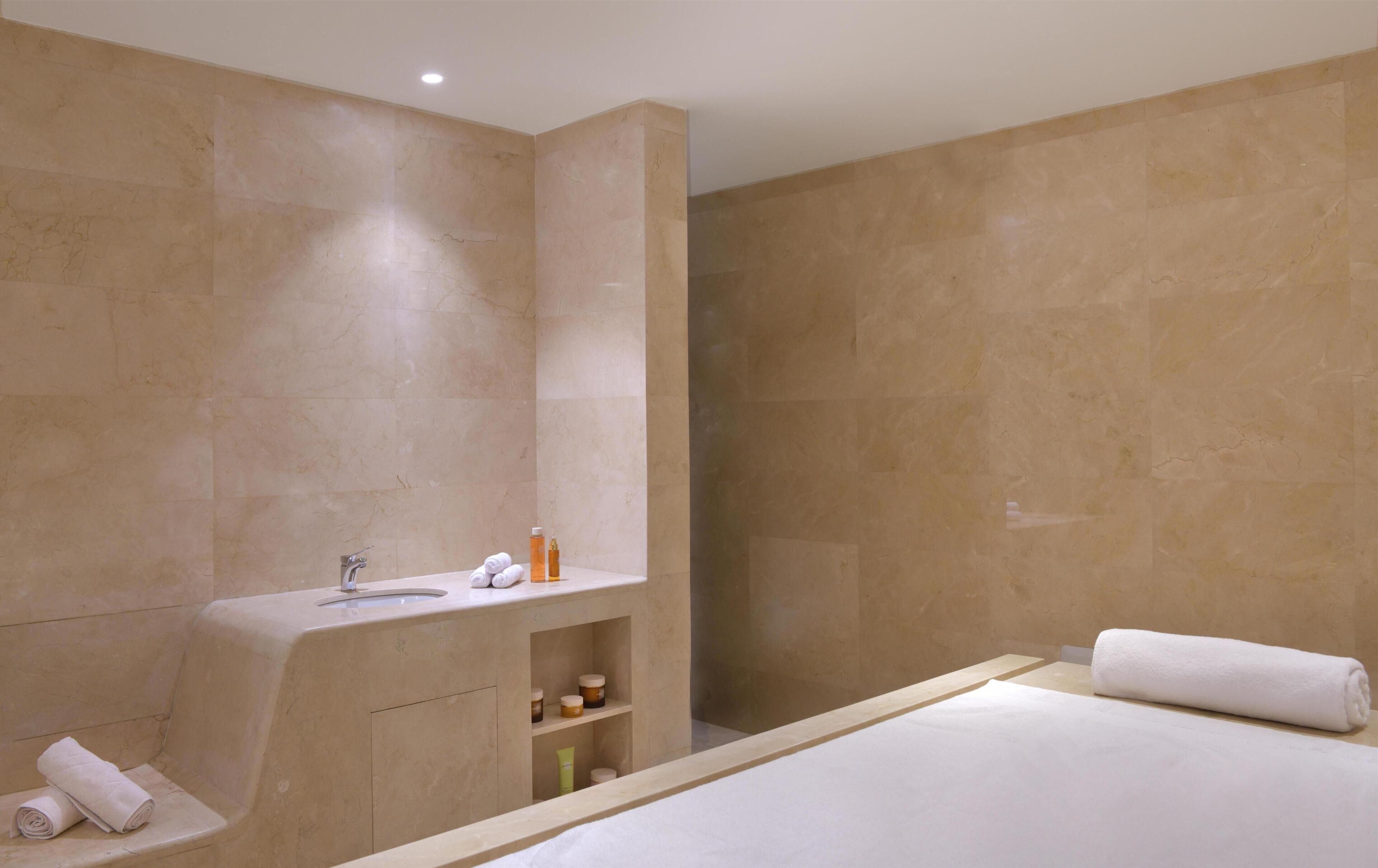 A modern bathroom with a bathtub, a sink, and a shower area.