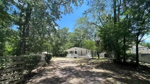 A residential area with a gravel driveway leading to a house with a porch. - Country and quiet place, for get a great vacation (Splendora)