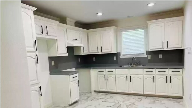 A kitchen with white cabinets, a black countertop, and a marble floor. - Country and quiet place, for get a great vacation (Splendora)