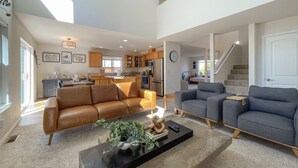 A spacious living room with a brown leather sofa, a grey sofa, and a black coffee table with decorative items. - Spotless Modern Spacious 1 min to Hurricane Ridge entrance Patio Family friendly (Port Angeles)