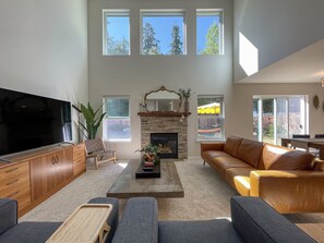 Amplia sala de estar con chimenea, un televisor de pantalla plana grande y asientos cómodos.