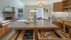 A modern kitchen with a central island, built-in cabinets, and a stone fireplace. - Spotless Modern Spacious 1 min to Hurricane Ridge entrance Patio Family friendly (Port Angeles)