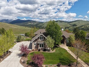 A residential house with a driveway, front yard, and a view of mountains.