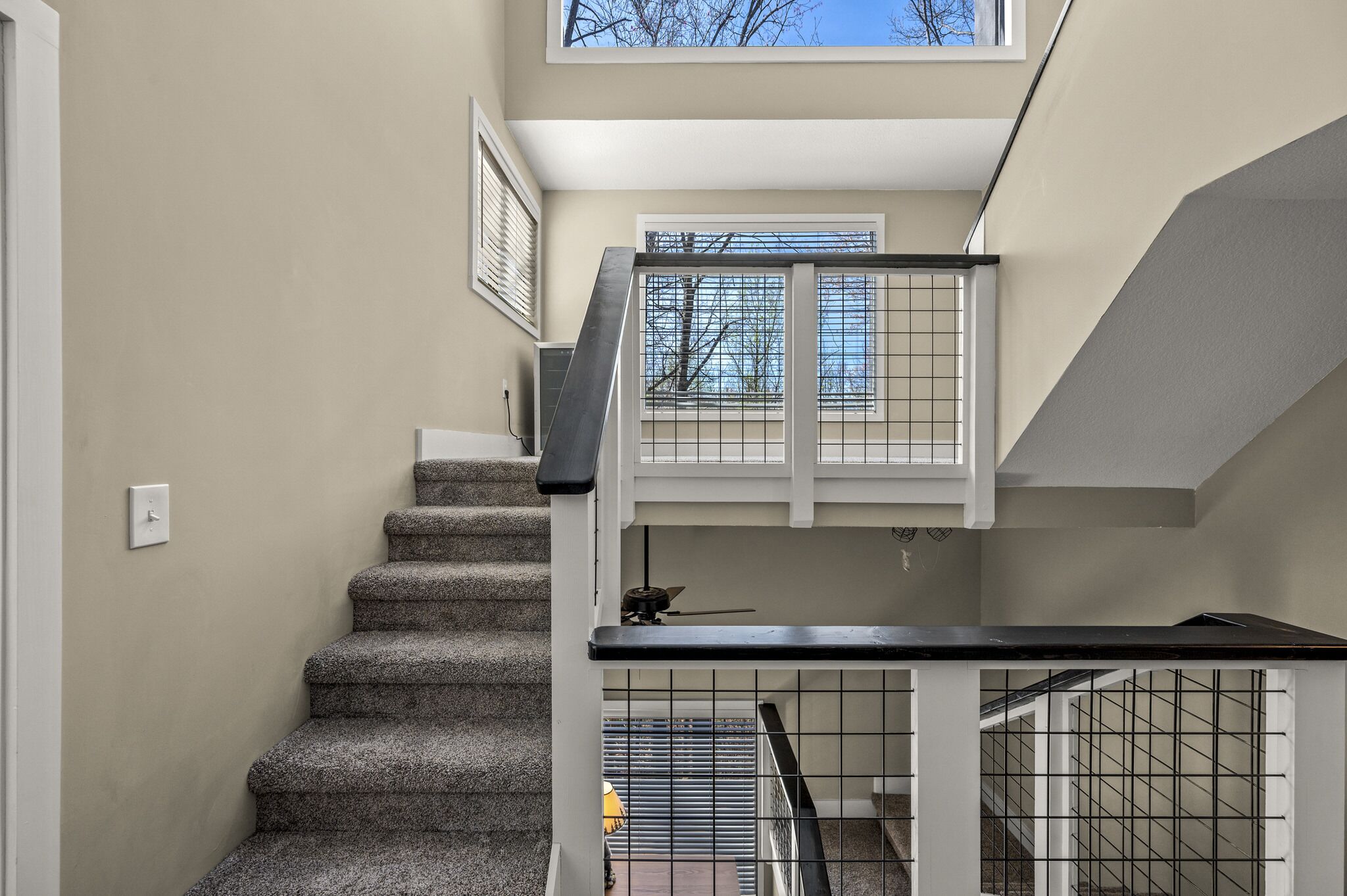 A staircase with a handrail and a window at the top.