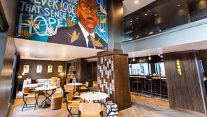 Een modern interieur met een muurschildering, zithoeken en een bar.
