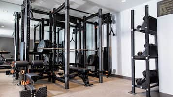 Una palestra con attrezzatura per sollevamento pesi, tra cui una panca per squat e panche.