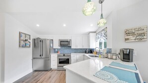 A modern kitchen with stainless steel appliances, a central island, and decorative lighting. - ☀️350yd2Beach-Patio-Bikes-Firepit-30A-Dunestruck☀️ (Santa Rosa Beach)
