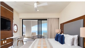 Une chambre d’hôtel avec un lit, une télévision, un bureau, une chaise et un balcon avec vue.