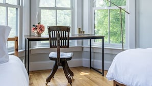A bedroom with a desk, chair, and large windows. - Raspberry Inn · Classic Riverfront Home-Mins to Woodstock & Skiing (Bridgewater)