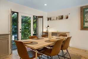 A dining area with a wooden table, six chairs, and a vase.
