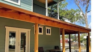 A two-story house with a covered porch and a small balcony.