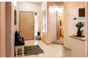 Stylish hallway with a bench, potted plant, and plush rug.