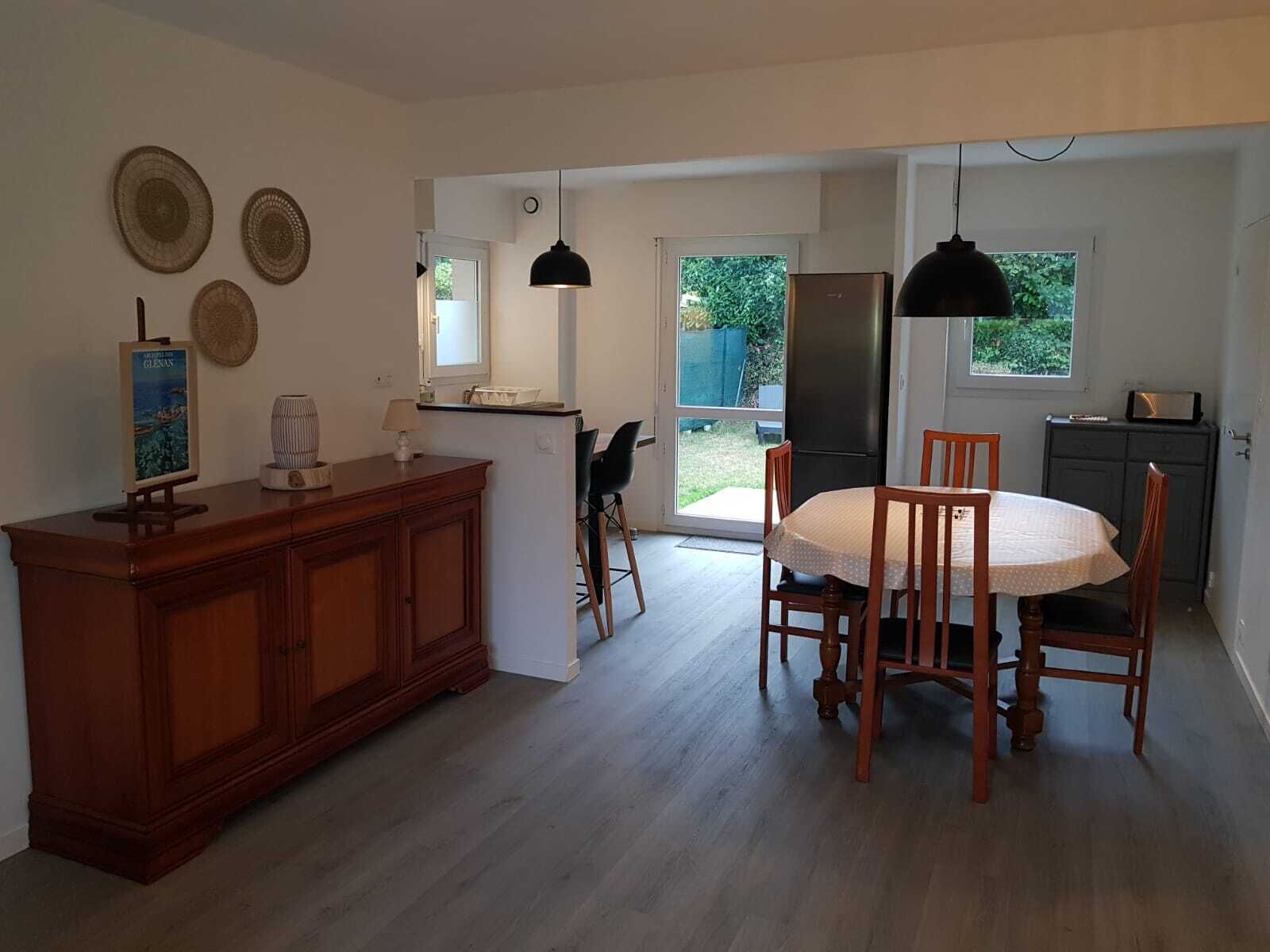 Una cocina amplia con comedor, armarios de madera y refrigerador.