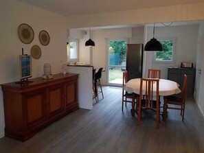 A spacious kitchen with a dining area, wooden cabinets, and a refrigerator.