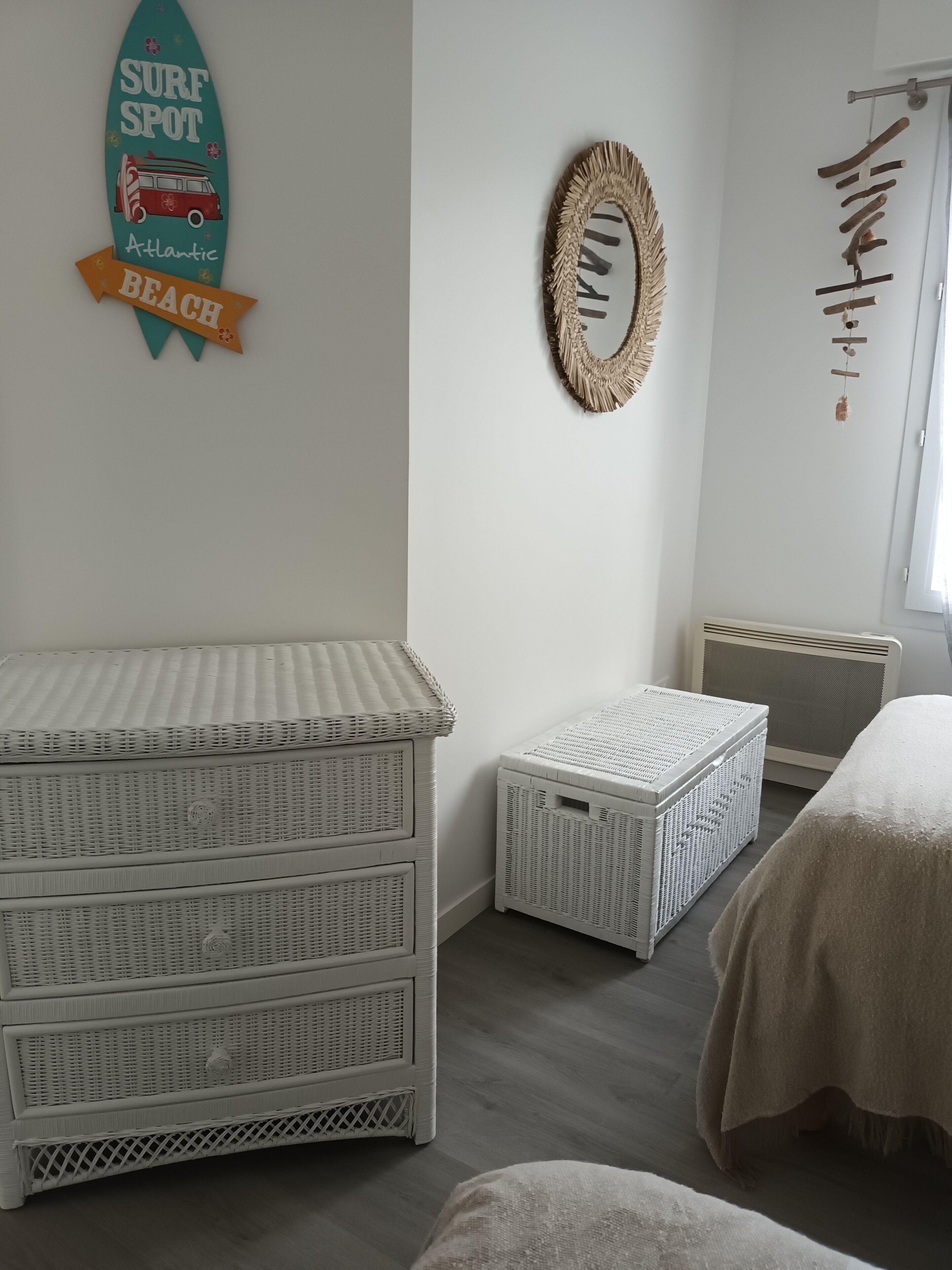 A room with wicker furniture, a surfboard decoration, and a wall clock.