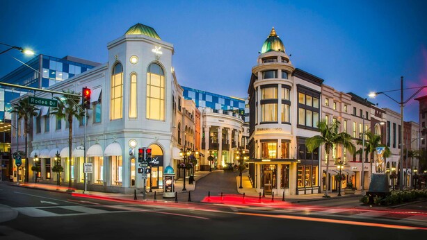 Straßenansicht von Rodeo Drive mit luxuriösen Boutiquen und einem historischen Gebäude mit Kuppel.