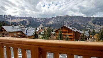 A wooden building with balconies and a view of mountains.