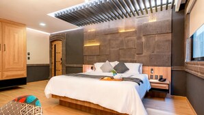 A modern bedroom with a large bed, wooden headboard, and a built-in nightstand. - Hotel Patio Santiago (Querétaro)
