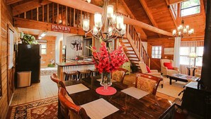 L’intérieur d’une cabane en bois comprend un coin repas, une cuisine et un escalier.