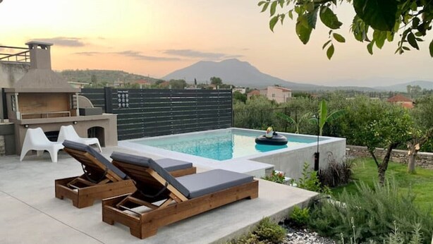 A pool area with lounge chairs and a barbecue setup. - The Backyard (Eva)