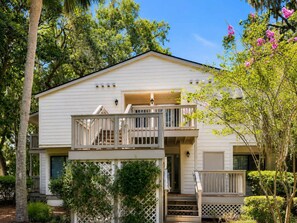 A two-story house with a balcony, a front porch, and a garage.