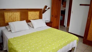 A neatly made bed with a bright green blanket, a wooden headboard, and white bedding. - Aito 2 in Muri (Muri)