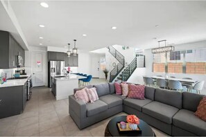 Relax in a spacious living area with a large sofa, coffee table, and city views from the upper level.