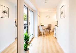 A modern kitchen with a dining area, a potted plant, and a view of the street. - Stylish apartment: quiet, 24/7 self check-in & Wi-Fi, street parking (Göttingen)