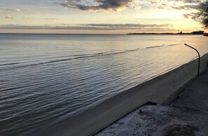 Ein Strand mit einer Betonpromenade entlang des Wassers.