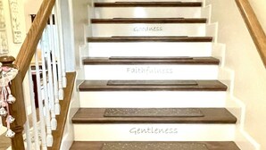 Eine Treppe, deren Stufen mit Tugenden wie Geduld, Freundlichkeit und Selbstbeherrschung beschriftet sind.