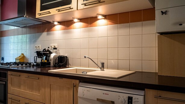 A modern kitchen with a gas stove, a coffee maker, a dishwasher, and a sink. - L'Intemporel - Appartement T3 avec jardinet - 3* (Poitiers)