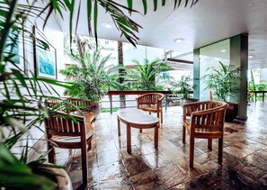 A spacious indoor area with wooden furniture and potted plants. - 1BR Ilikai Marina Ocean View 5 Star Location (Honolulu)