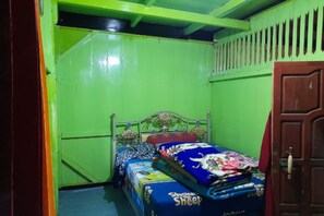 Una habitación pequeña y de colores vivos con una cama individual, una puerta y una ventana.