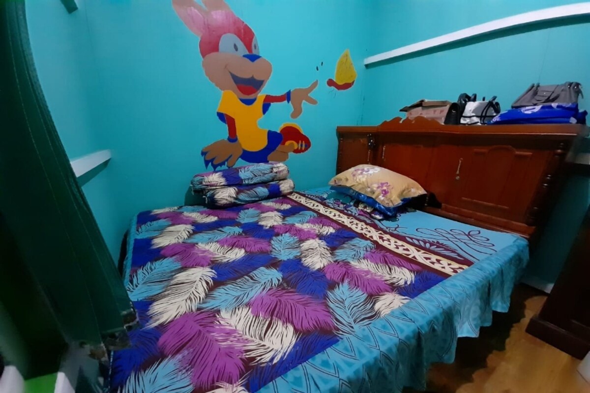 Un dormitorio con una cama, un armario de madera y un mural en la pared.