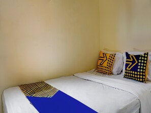 A single bed with white bedding and two pillows with geometric patterns. - OYO Homes 91132 Desa Wisata Kalipucang (Purwosari)