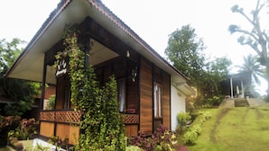 Ein Holzhaus mit Ziegeldach, umgeben von üppiger Vegetation und einem gepflegten Garten.
