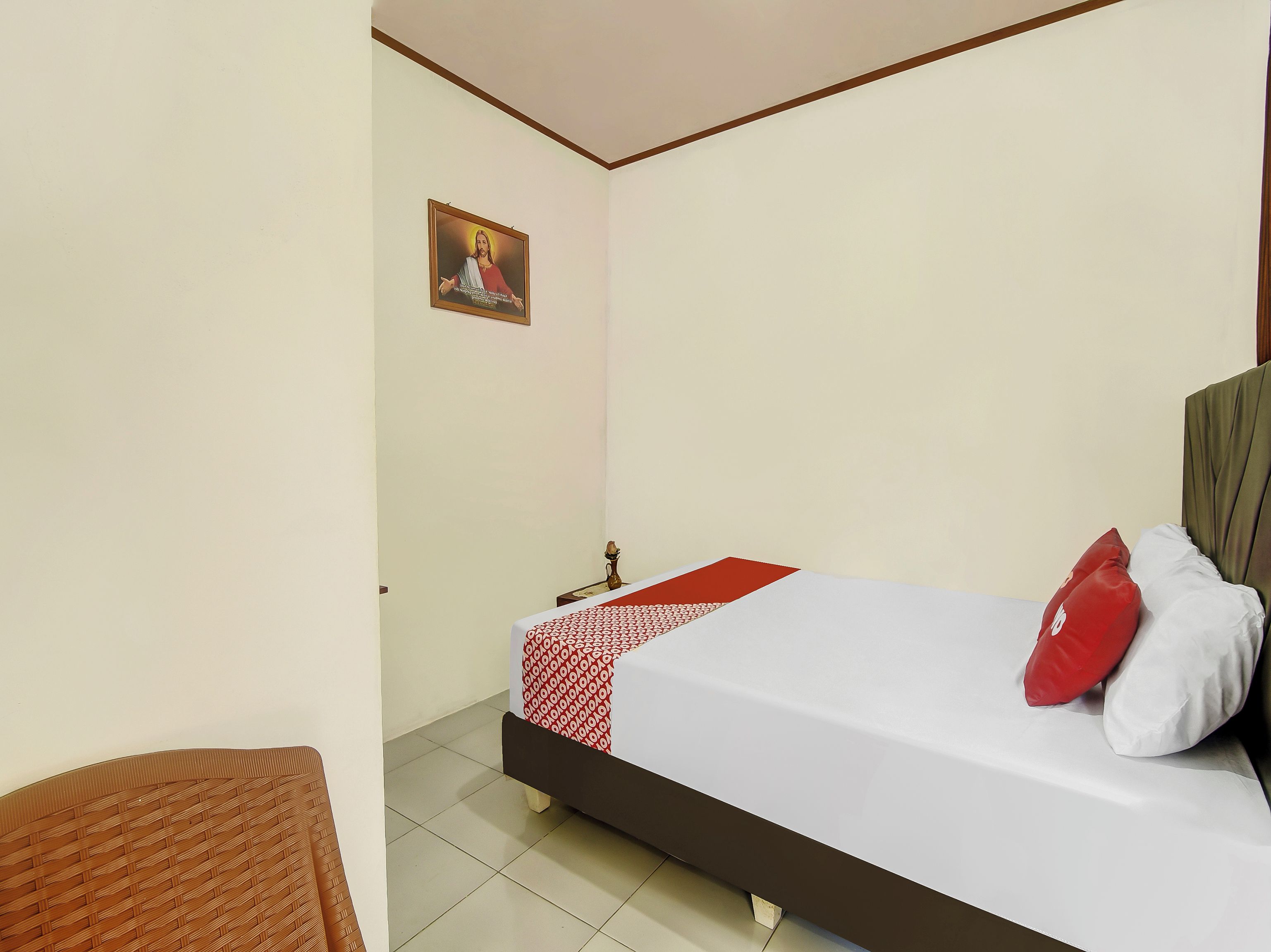 Un dormitorio con cama, mesita de noche, un cuadro en la pared y una silla.