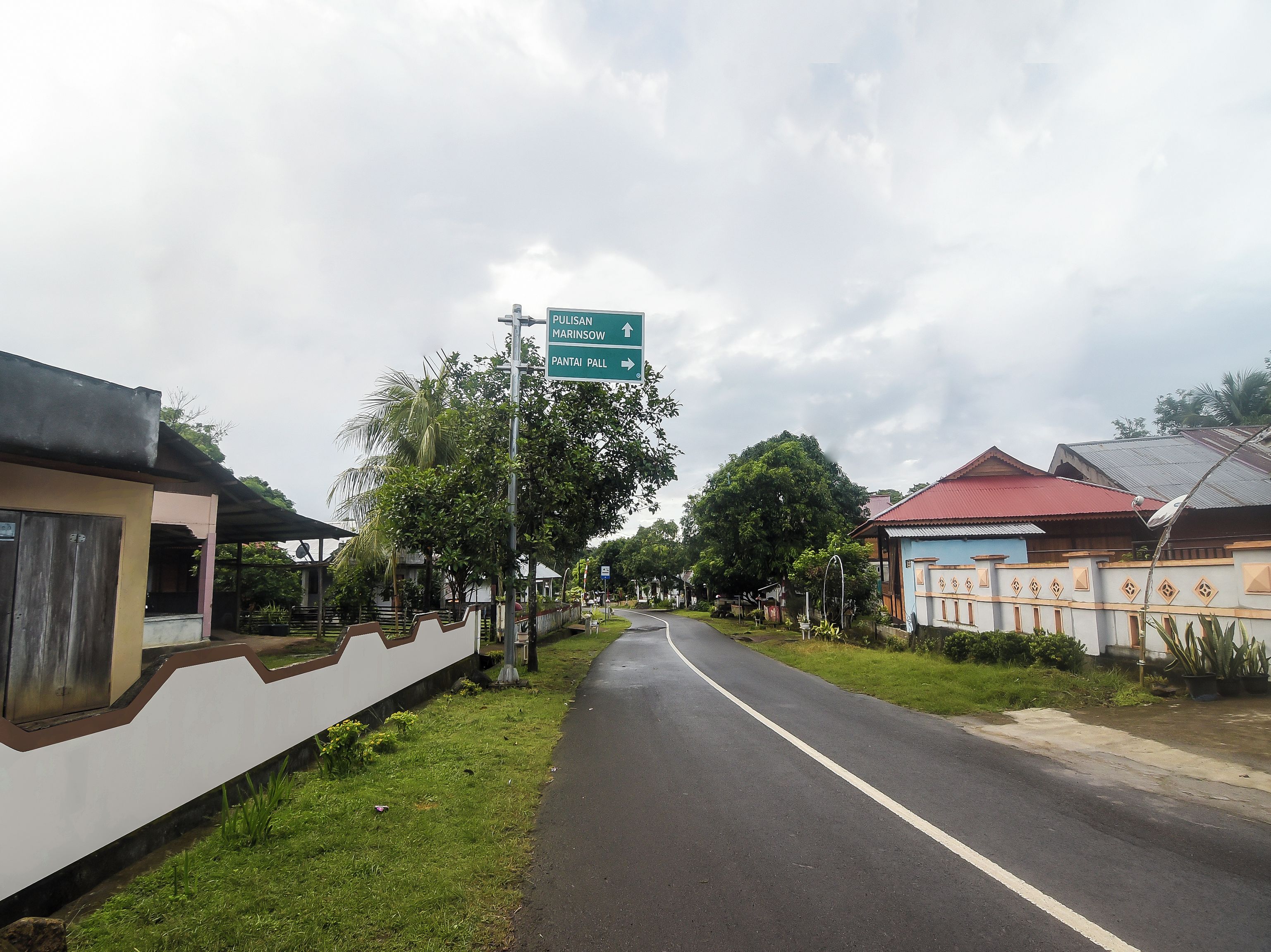 A road with a directional sign indicating destinations.