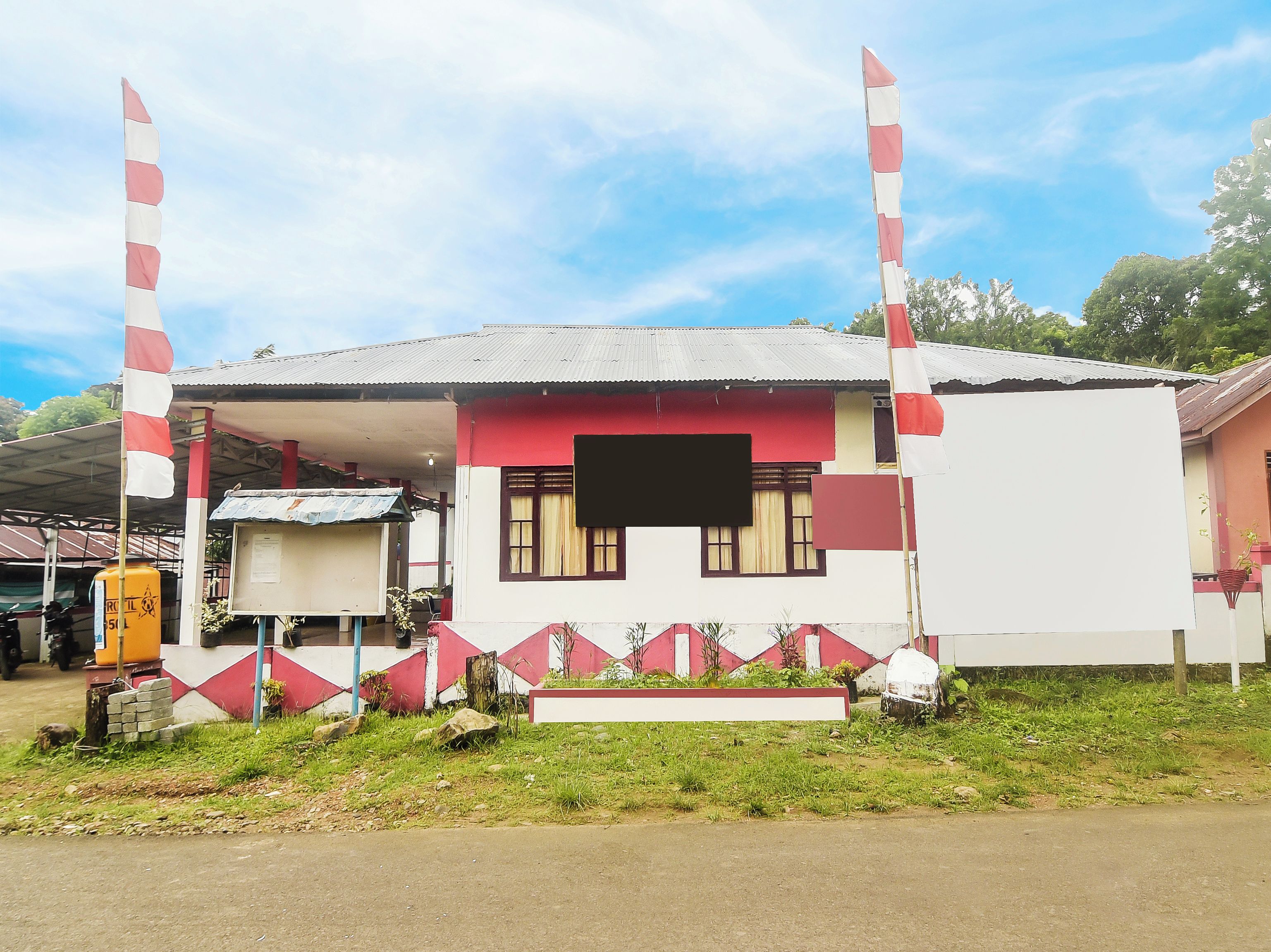 A building with a red and white facade, a covered porch, and a flagpole.