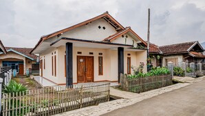 A single-story house with a tiled roof, a front porch, and a fenced yard. - OYO 90997 Eco Desacibodasbabakangentong2syariah (Lembang)