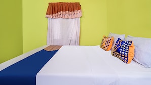 A room with a bed, pillows, a window with curtains, and a wall-mounted picture frame. - OYO 90997 Eco Desacibodasbabakangentong2syariah (Lembang)