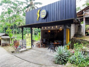 Un restaurante con fachada rústica, mesas al aire libre y un menú a la vista.